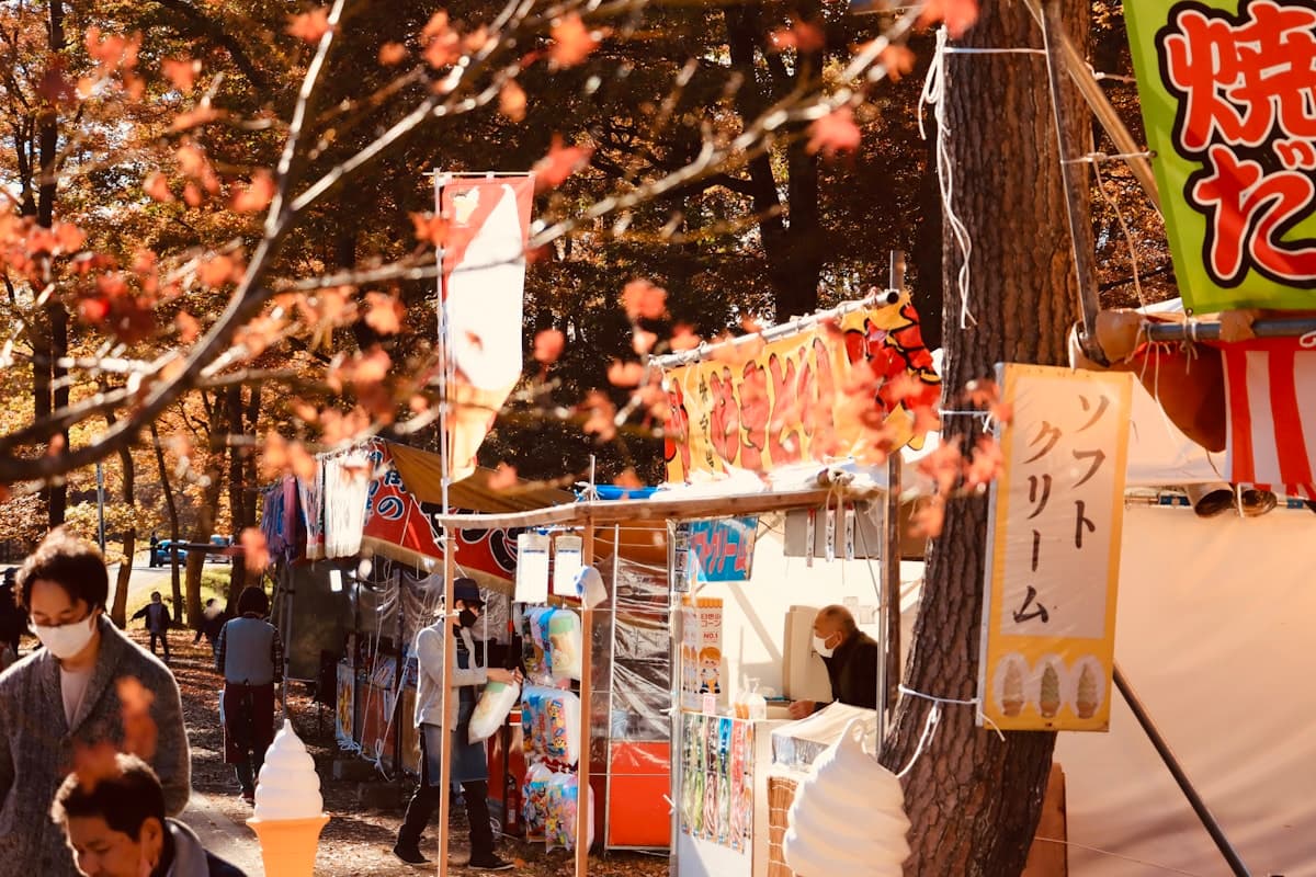 Autumn festival food stalls beneath colorful trees