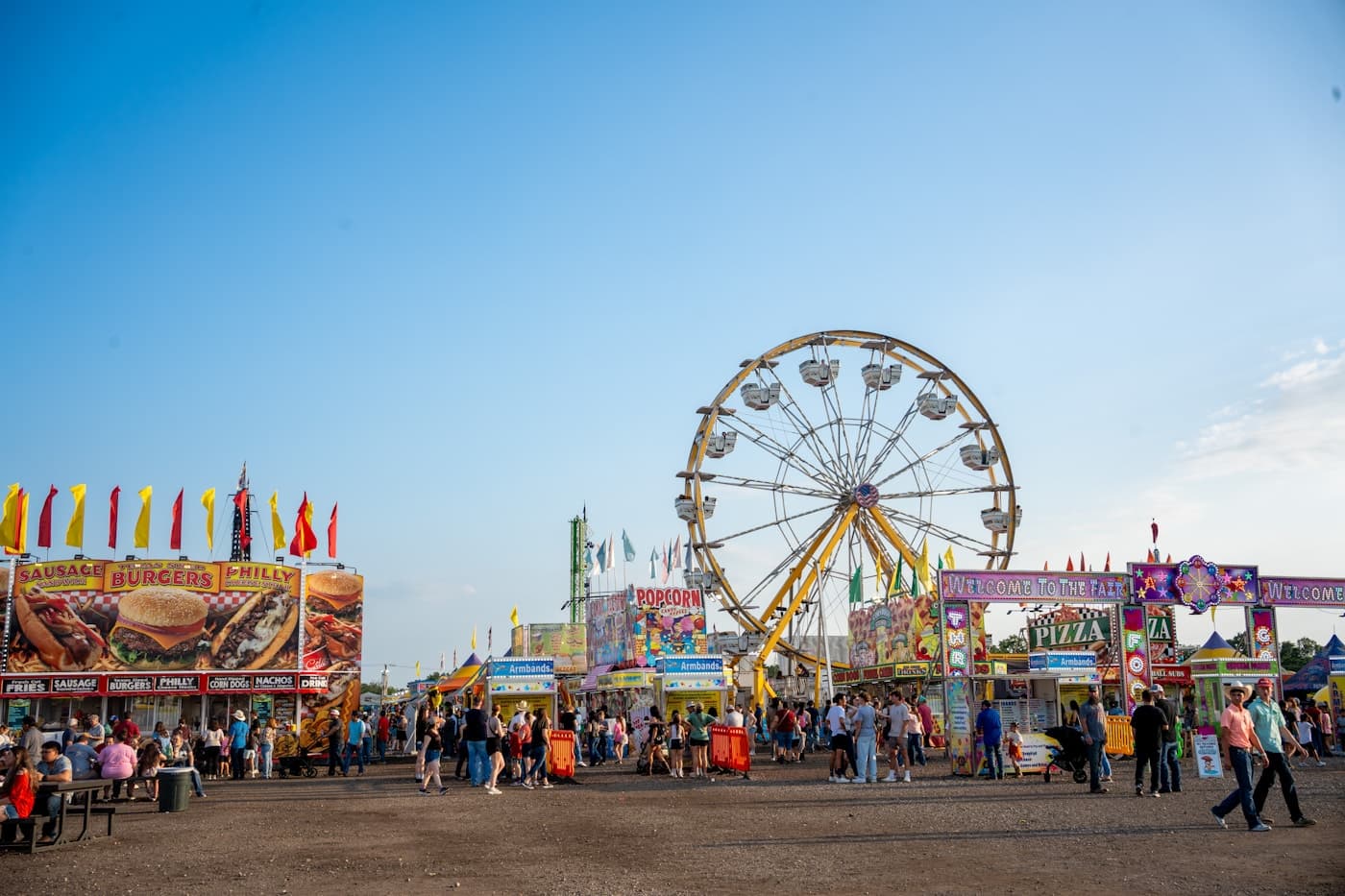 Fall fair midway with a Ferris wheel and food stalls