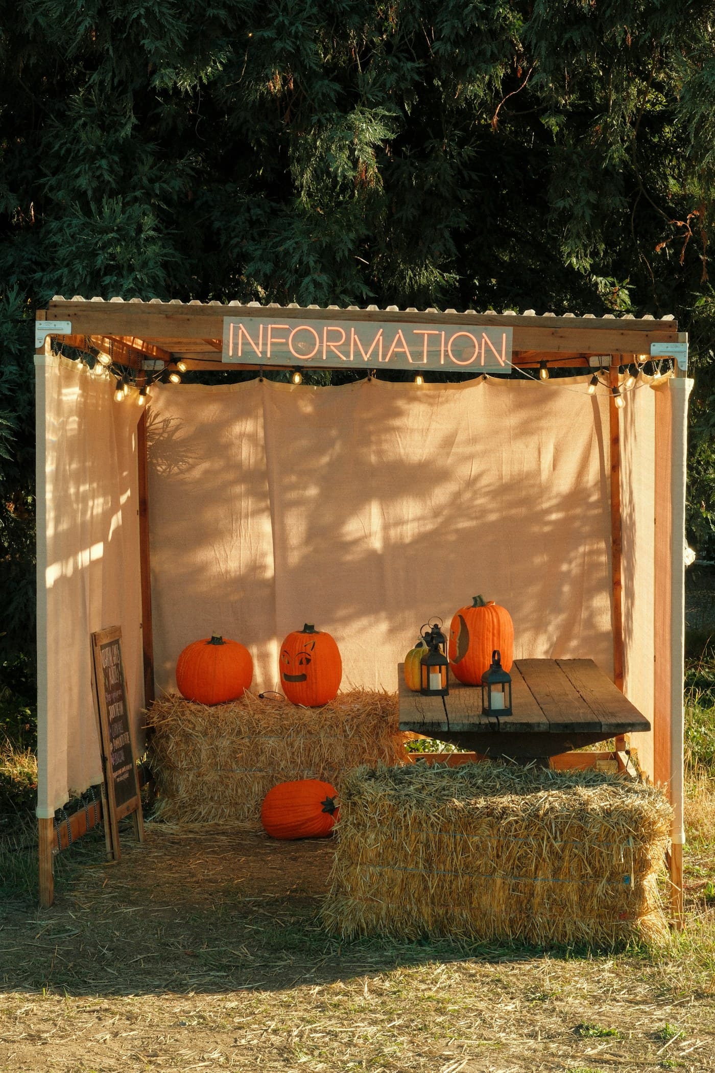 Fall festival information booth decorated with pumpkins and hay bales